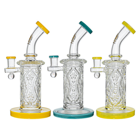 Three Calibear Premium Wall Perc Dab Rigs displayed side by side in yellow, teal, and yellow-green colorways — each featuring a thick clear borosilicate cylindrical body with intricate raised baroque damask wall texture, colored flat disc base and mouthpiece cap, angled curved neck, side quartz banger joint with carb marble, and flat color-rimmed disc base, standing 8.6 inches tall with a 14.5mm joint.