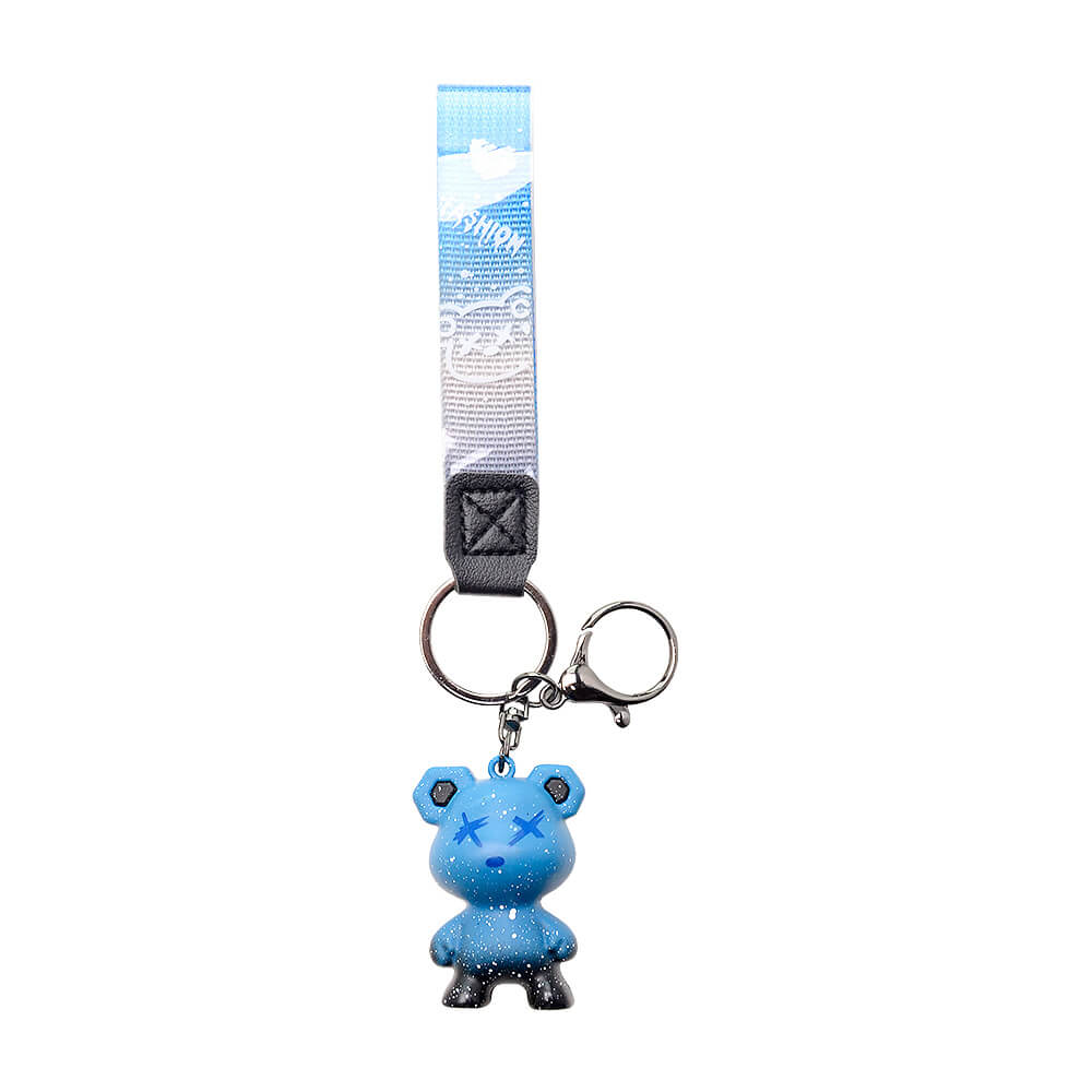 Five Calibear collectible streetwear bear keychain figurines in black, green, blue, purple, and red alongside a premium black and silver metal Calibear bear paw logo keychain.