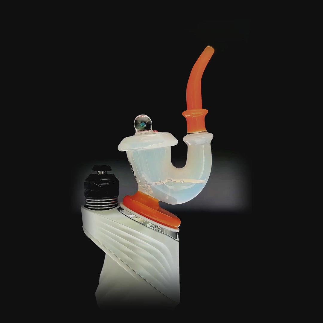 Three Calibear Sherlock Pipe glass attachments in green, clear-orange, and blue colorways mounted onto black Puffco Peak e-rig bases, showcasing curved necks and internal styling.