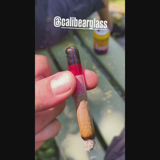 function video of Calibear premium reusable glass filter tips shown side-by-side with gold logos, featuring a pink base with a green dichro top, a lime green base with a rainbow wigwag top, and a red base with a dark shimmering dichro top.