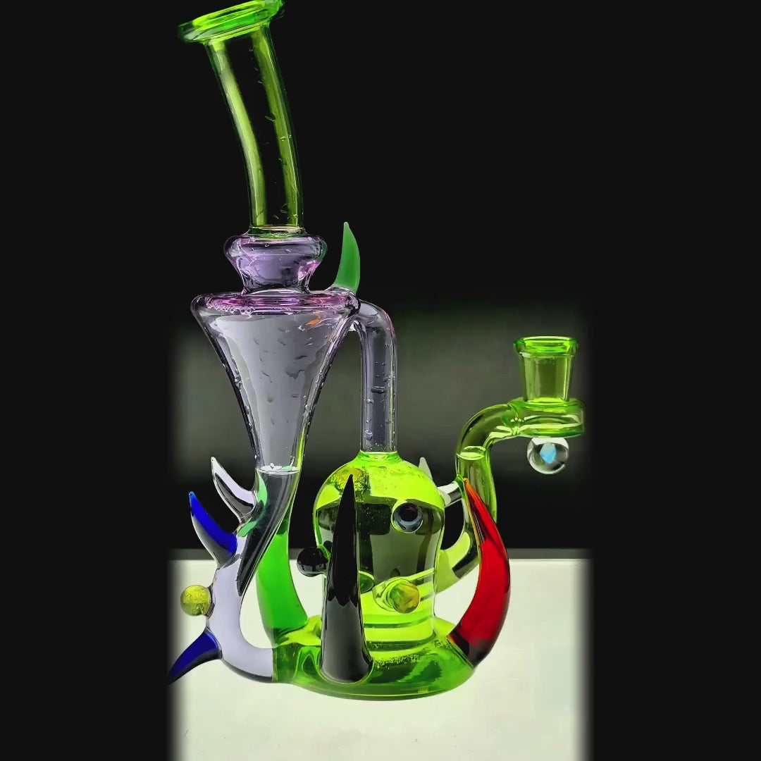 function video of CaliBear monster alien incycler dab rig featuring a green bio-organic body, purple tentacle-style recycler drains, and a premium encased opal.