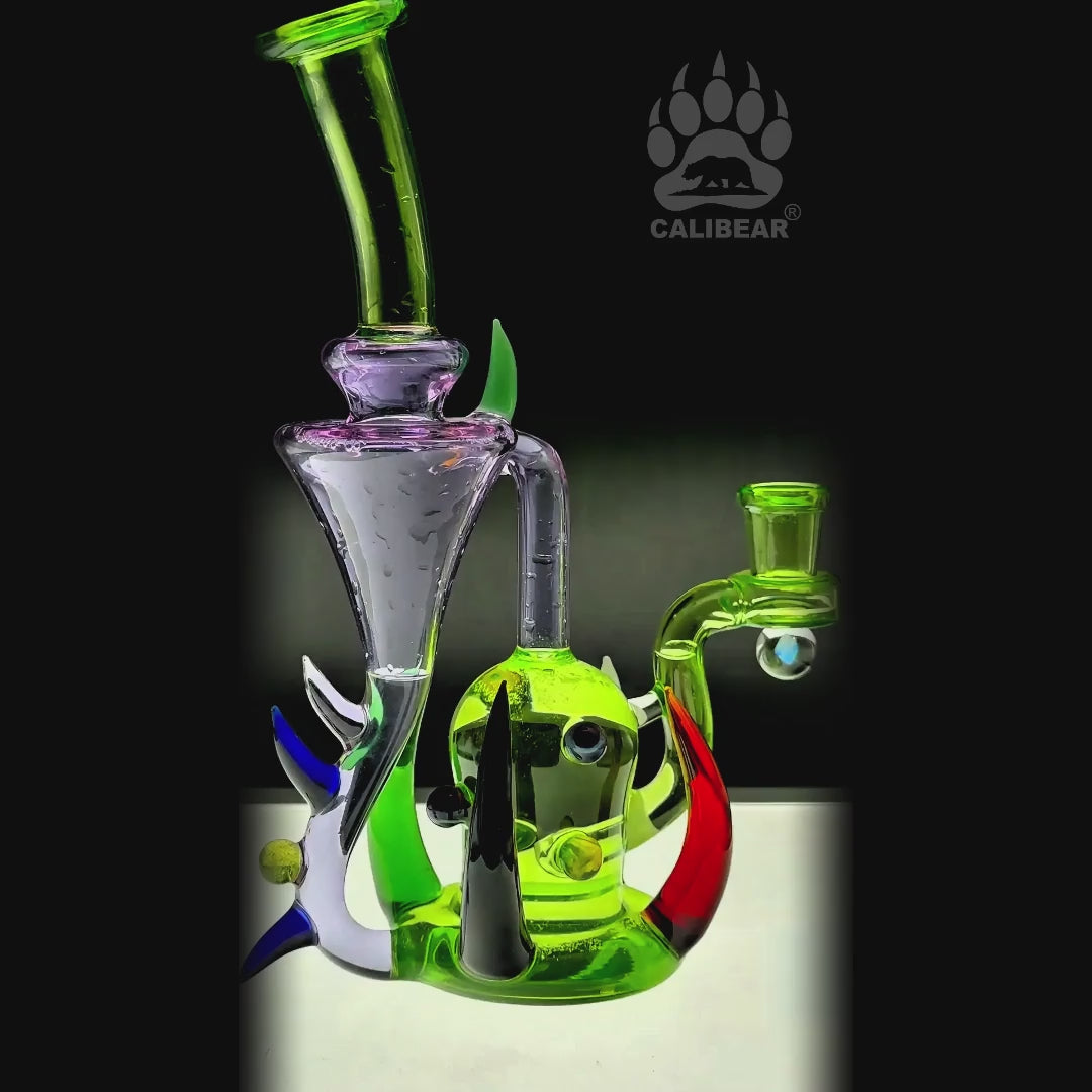 function video of CaliBear monster alien incycler dab rig featuring a green bio-organic body, purple tentacle-style recycler drains, and a premium encased opal.