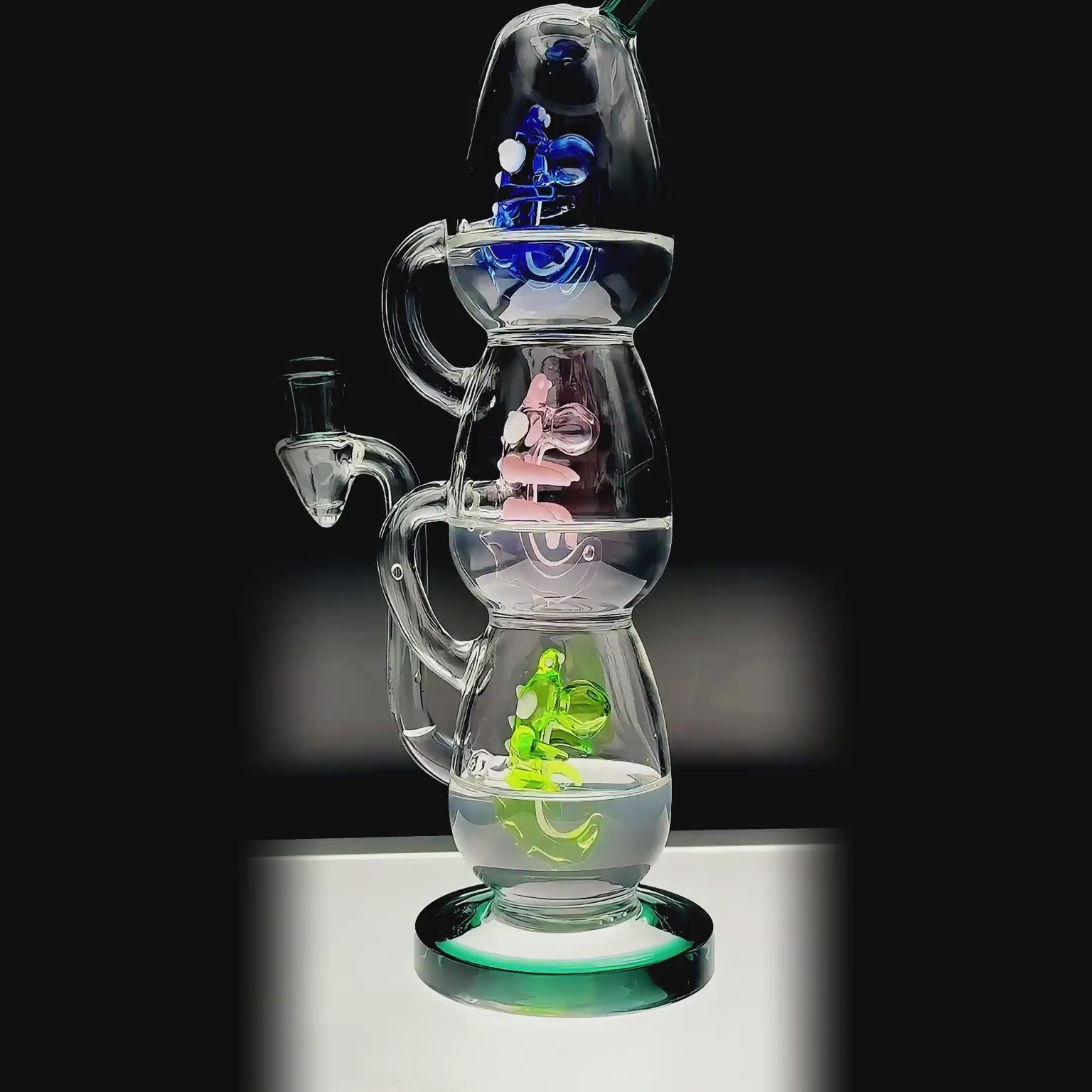 Calibear Triple Yoshi Egg recycler dab rig showcasing four stacked glass water pipe color options in purple, green, blue, and black accents with blue, pink, and green internal egg percolators.